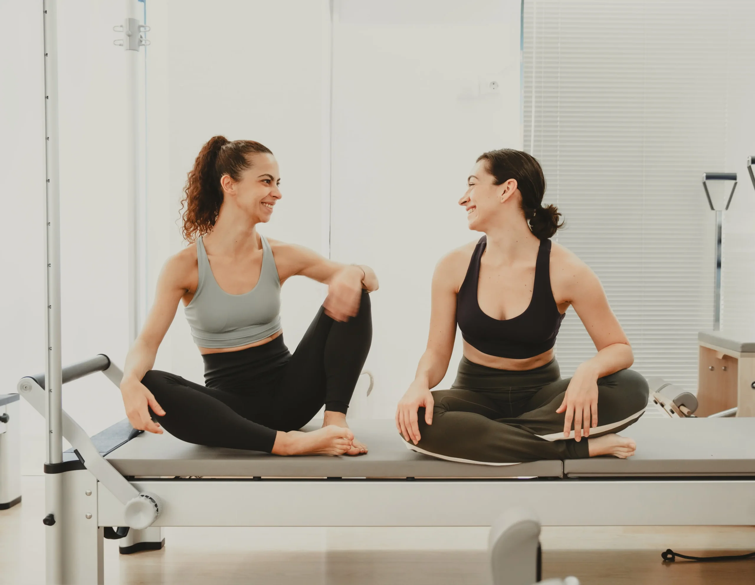 Dos mujeres conversan sonrientes tras una clase de pilates en Siamo Pilates Madrid