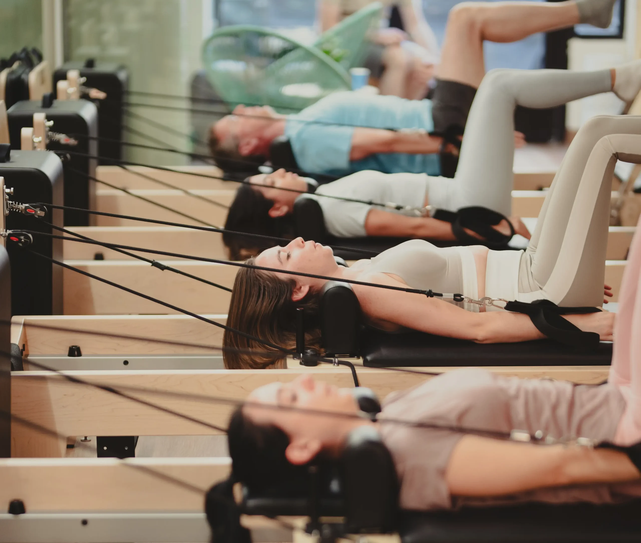 Alumnos practicando pilates en máquinas reformer en grupo en Siamo Pilates Madrid