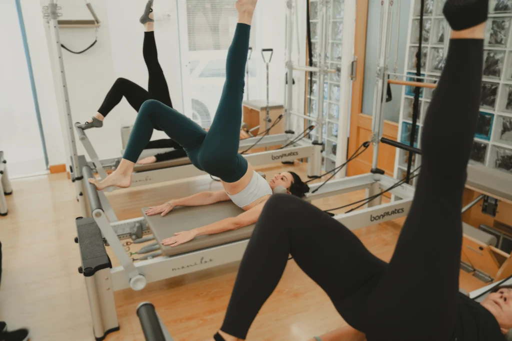 Ejercicio de fuerza de core en clase de pilates reformer en Siamo Madrid