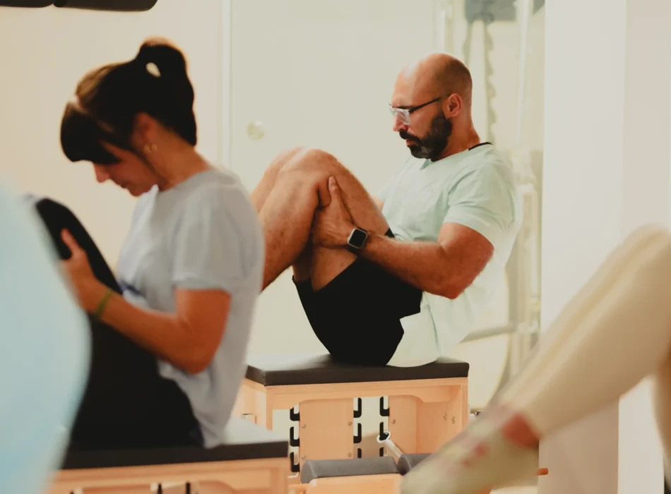 Pilates con Wunda Chair – Sesión en grupo Hombre realizando ejercicio de pilates en Wunda Chair en Siamo Pilates Madrid
