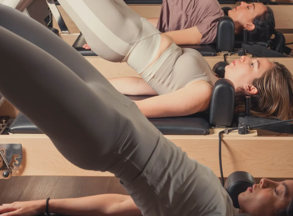 Sesión de pilates en reformer en grupo Clase grupal de pilates con ejercicios en reformer
