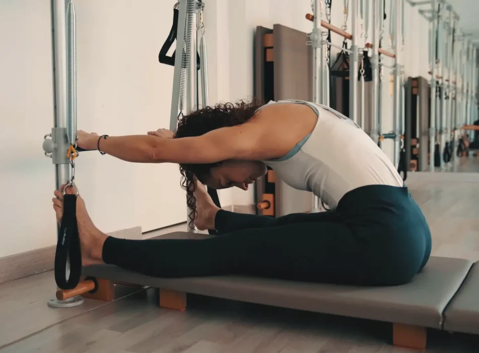 Alumna haciendo estiramiento asistido con torre en Siamo Pilates Madrid