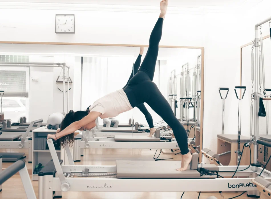 Mujer practicando pilates dinámico con reformer en Siamo Pilates Madrid